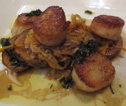 Pan Seared Scallops with sauteed carrots and cabbage, confit potato, white bean puree and pesto garnish.