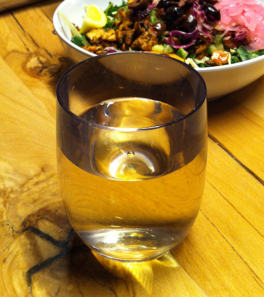 Glass of white wine with salad bowl