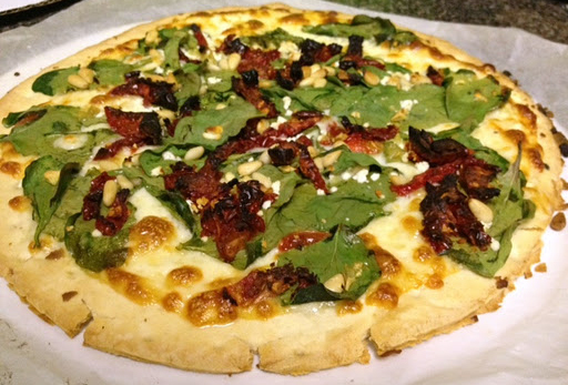 Spinach Pie with feta cheese, sundried tomatoes, roasted garlic, pine nuts, and oregano over an olive oil glaze